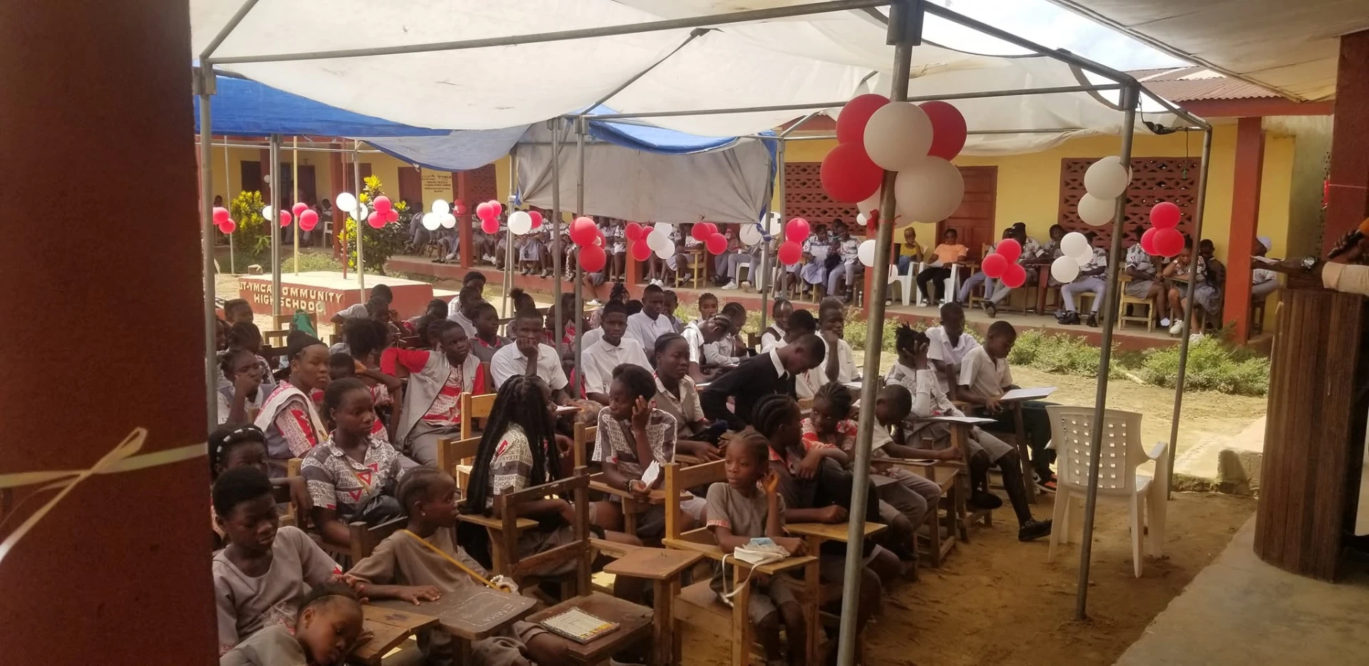Students gathered under canopies for a campus celebration